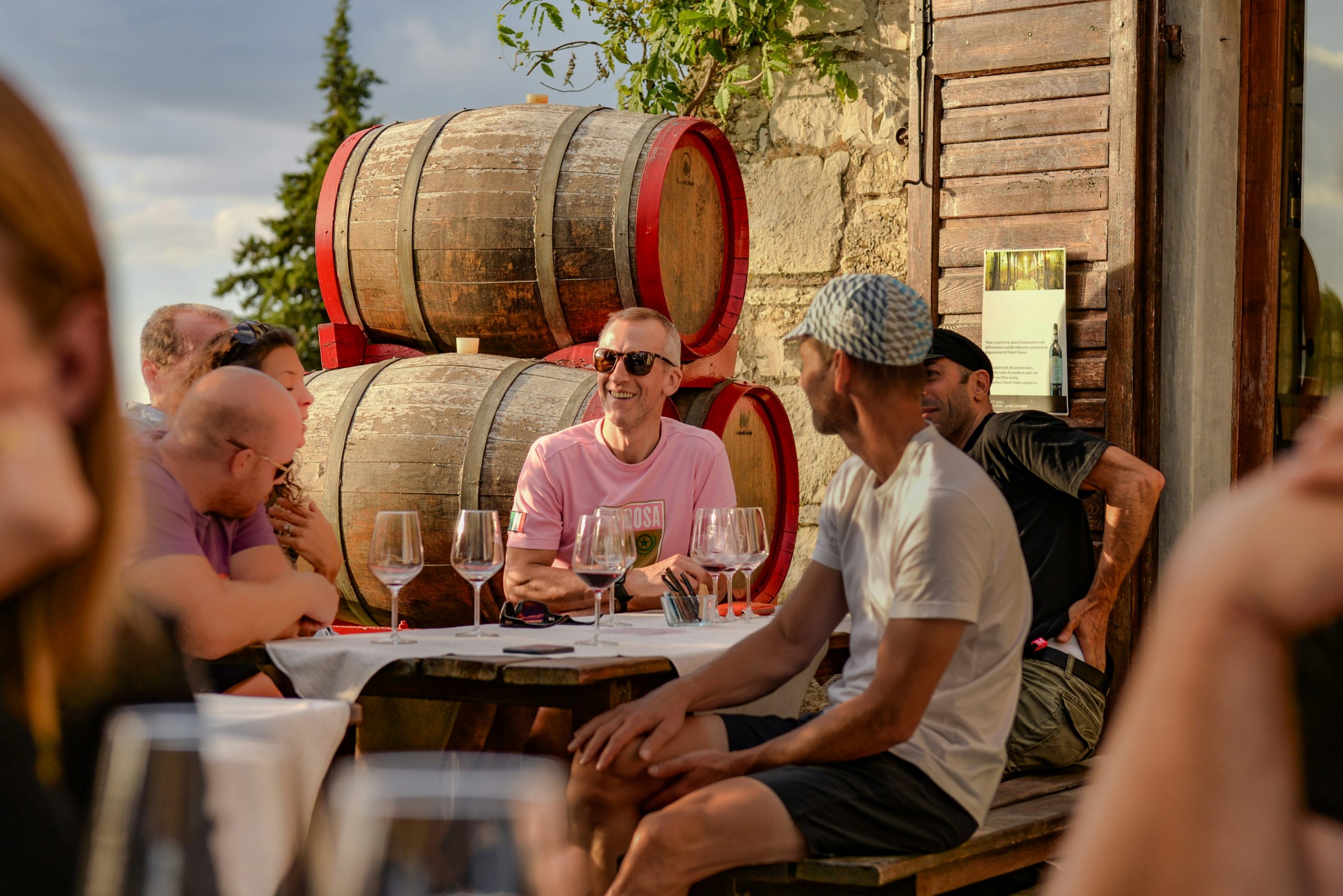 Visiteurs participant à une expérience œnotouristique devant des barriques
